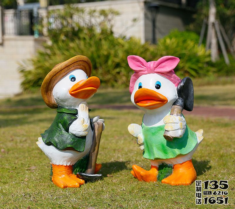 草地上手拿鋤頭和抗鏟子的兩只玻璃鋼彩繪鴨子雕塑 草地上手拿鋤頭和抗鏟子的兩只玻璃鋼彩繪鴨子雕塑